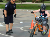 Officer teaching young boy road skills