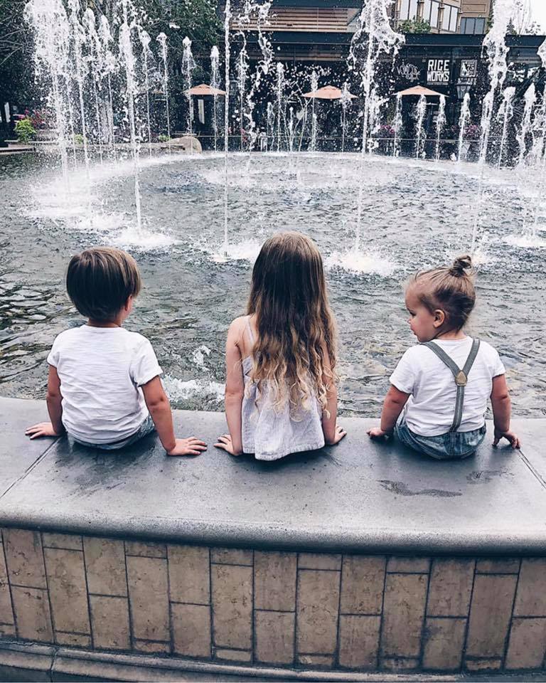 Three children sitting with their back to the camera at the Village at Meridian water display